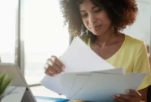 Mulher sorrindo em organizar documentos pessoais