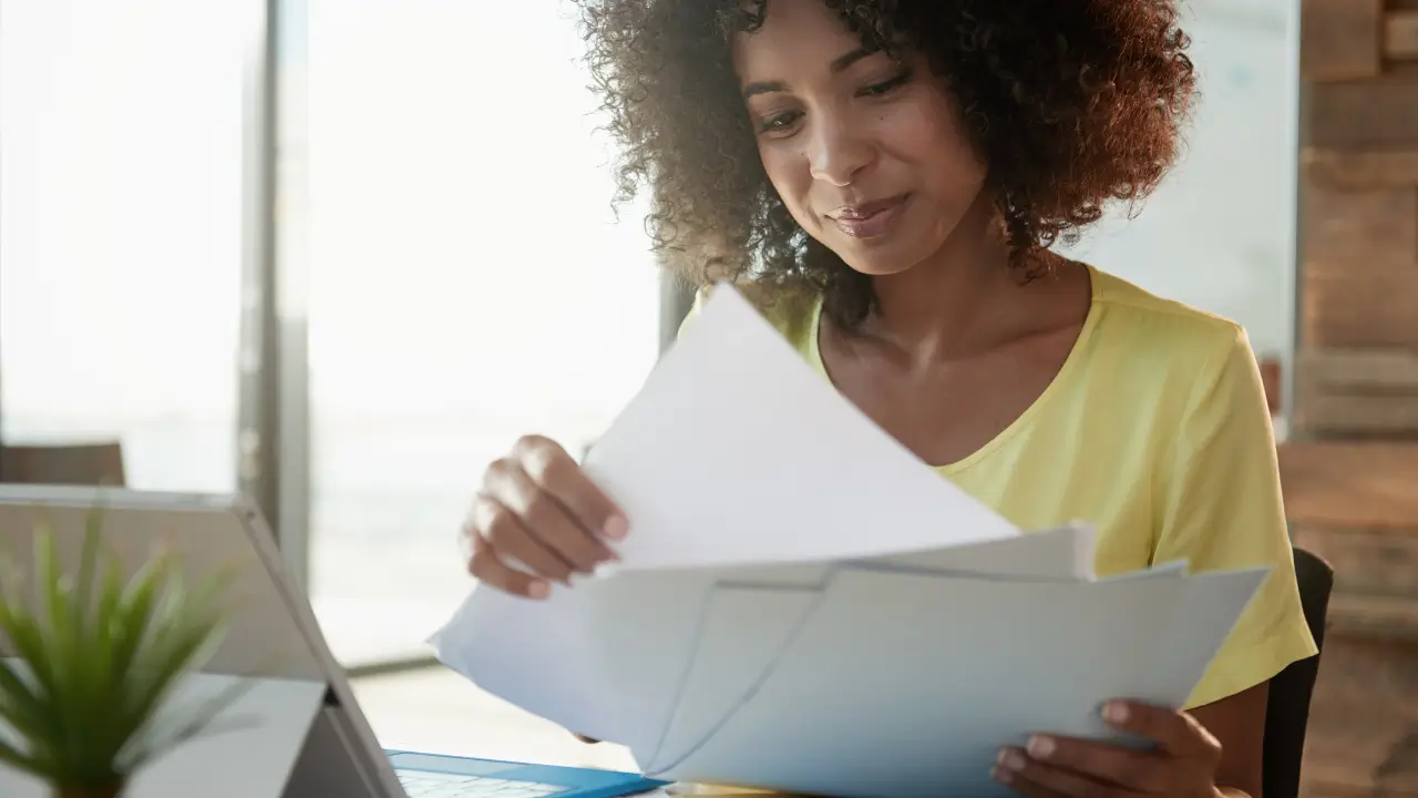 Mulher sorrindo em organizar documentos pessoais