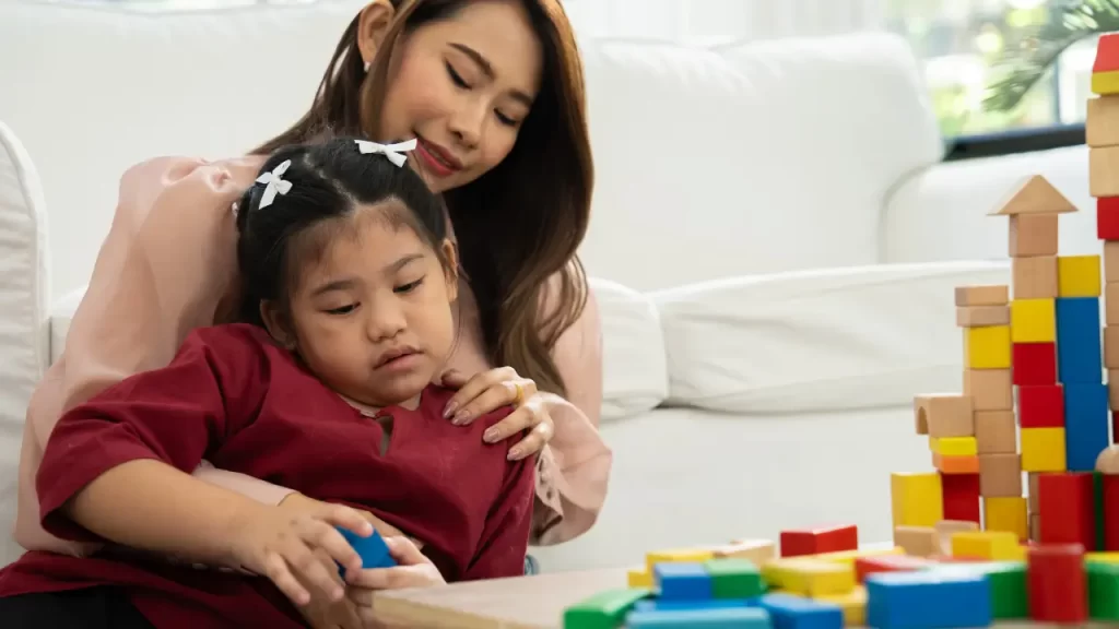 mãe atípica com criança brincando de blocos
