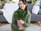 mulher com uma planta nas mãos demonstrando o poder das plantas na rotina da casa